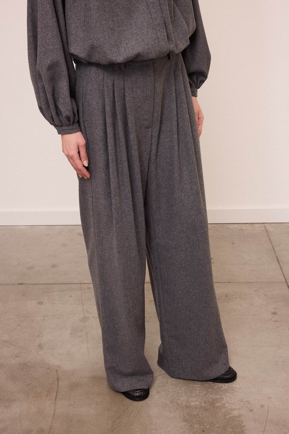 Pantalone in lana grigio con tre pinces frontali, passante in vita e gamba ampia 